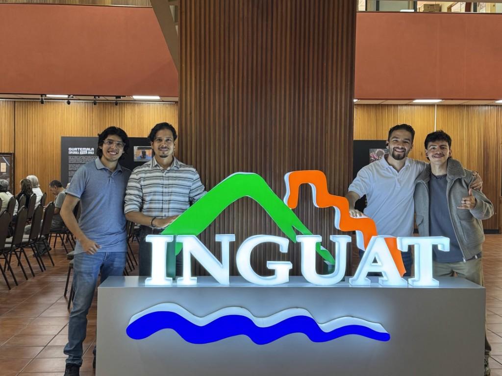 El equipo de Entre Ceibas junto al letrero de INGUAT.