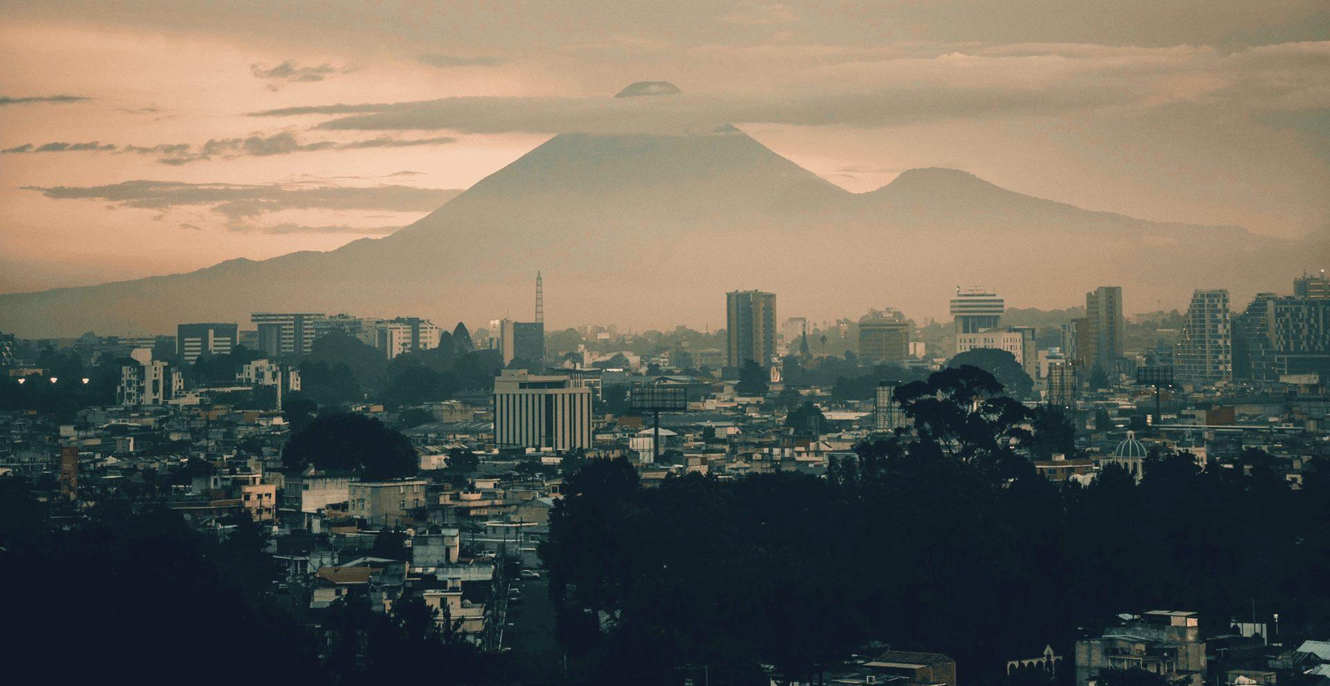 Ciudad de Guatemala al atardecer con el volcán de Agua al fondo