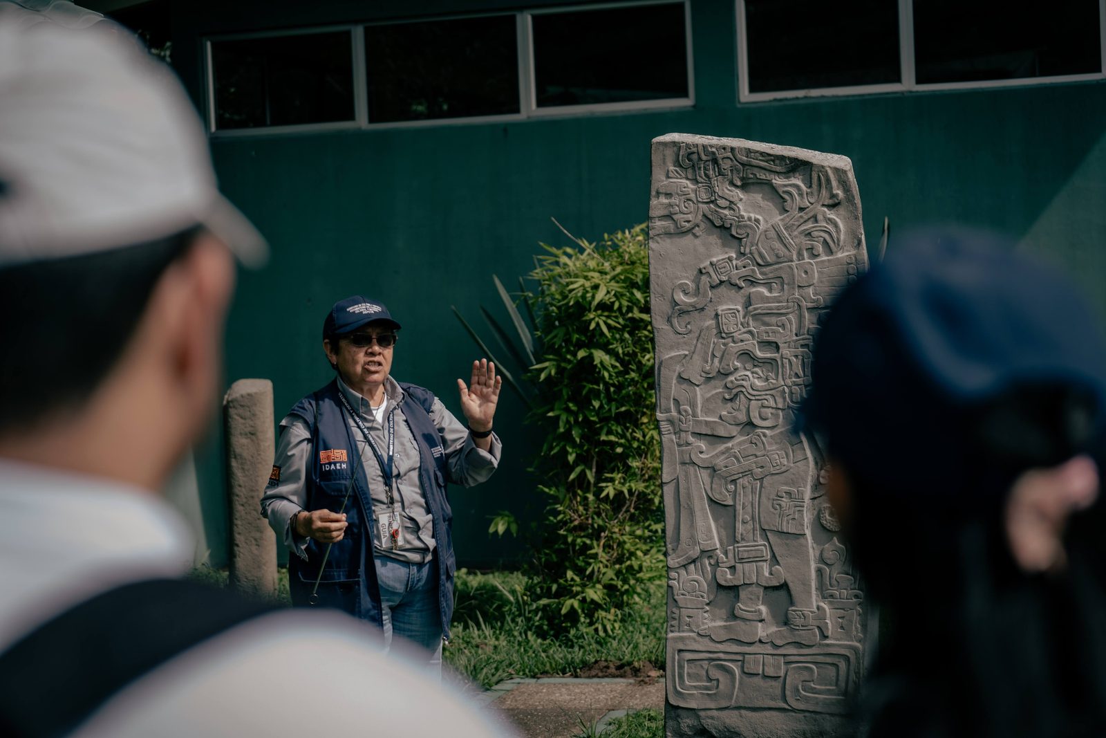 Guía explicando una estela maya a un grupo